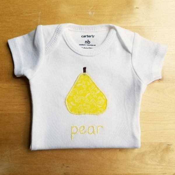 hand embroidered pear bodysuit on table