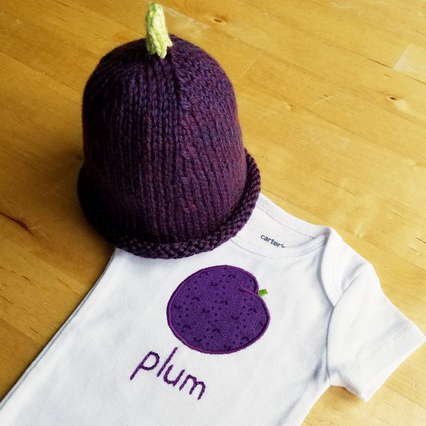 plum bodysuit and hat on table