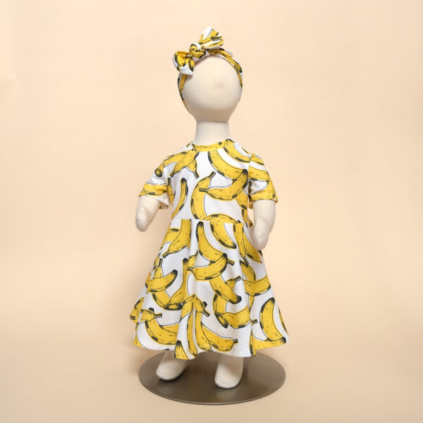 short sleeve luna dress in banana print on mannequin with eva headband